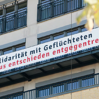 Ein Banner an der Fassade der Hochschule mit der Aufschrift Solidarität mit Geflüchteten